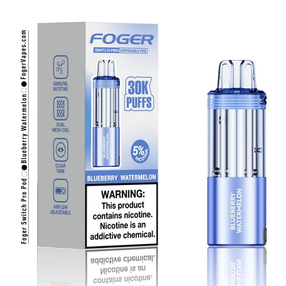 Foger Switch Pro Blueberry Watermelon Disposable Pod - 30,000 Puffs Vape Device with 5% Nicotine, Dual Mesh Coil, and Adjustable Airflow. The sleek light blue device features a clear tank and bold Blueberry Watermelon branding. The packaging highlights the sweet fusion of ripe blueberries and juicy watermelon for a refreshing and fruity vaping experience, perfect for long lasting satisfaction.